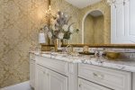 This powder room has nothing but the best with granite counter tops and gold fixtures